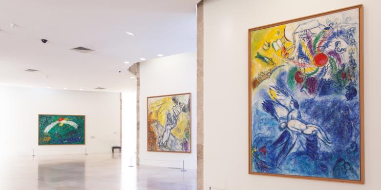  Vue de la salle du Message Biblique, avec les peintures de Marc Chagall (de gauche à droite) : Noé et l’arc-en-ciel (1961-1966), Moïse et les Tables de la Loi (1960-1966) ; La Création de l’Homme (1956-1958). Photo : musées nationaux du XXe siècle des Alpes-Maritimes / Gilles Ehrentrant, 2022 © Adagp, Paris, 2022