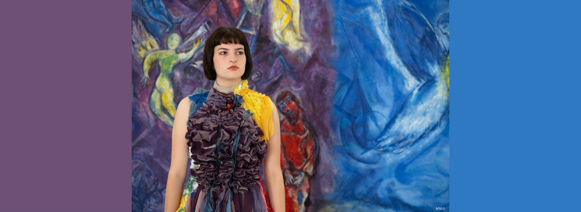 Fille aux cheveuax coourt en pose devant un tableau Chagall