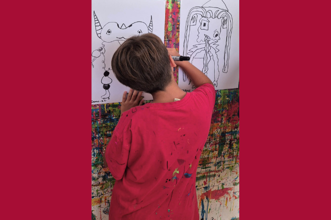 Visuel montrant un enfant dessinant un costume pour les ateliers créatifs en lien avec la création du monde