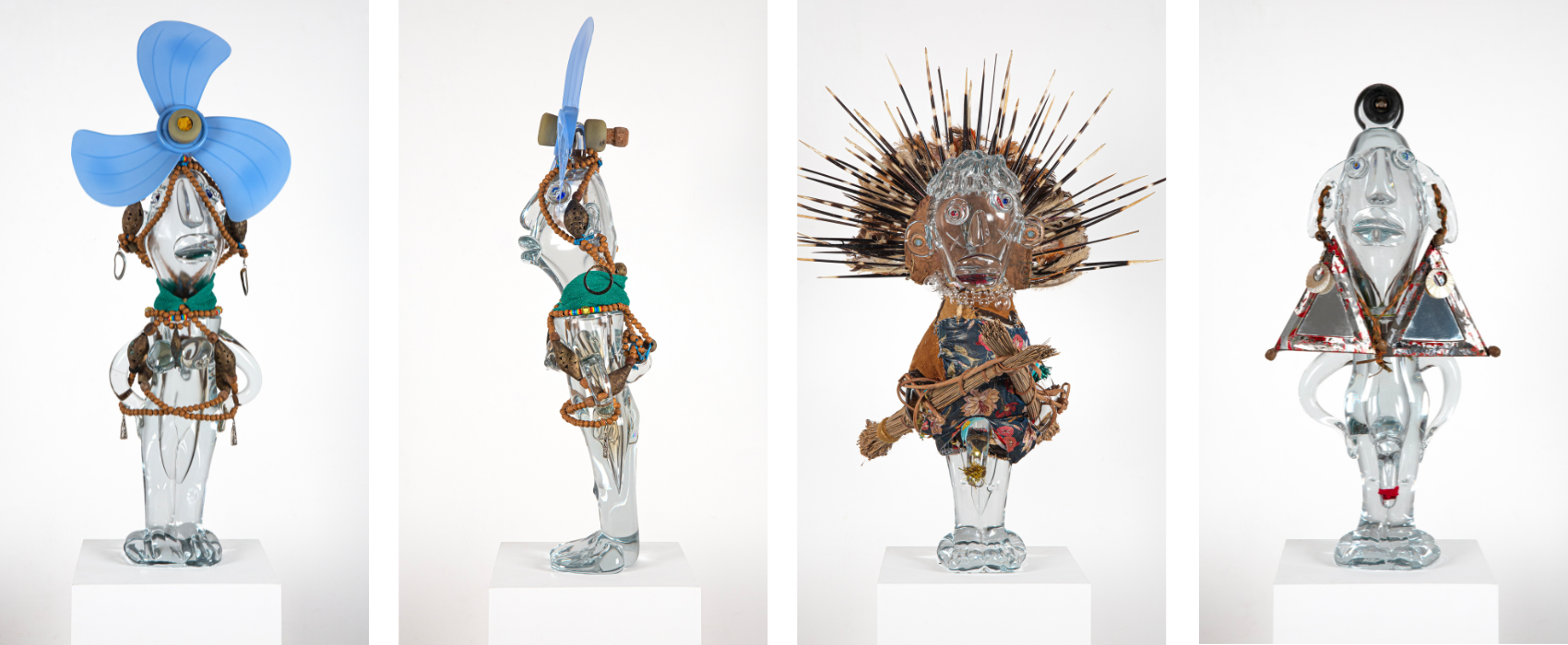 Quatre vues des Poupées Pascale, sculptures anthropomorphes en verre transparent, assemblée avec des matériaux de récupération, des textiles, des bijoux et des éléments végétaux, présentée sur un socle blanc.